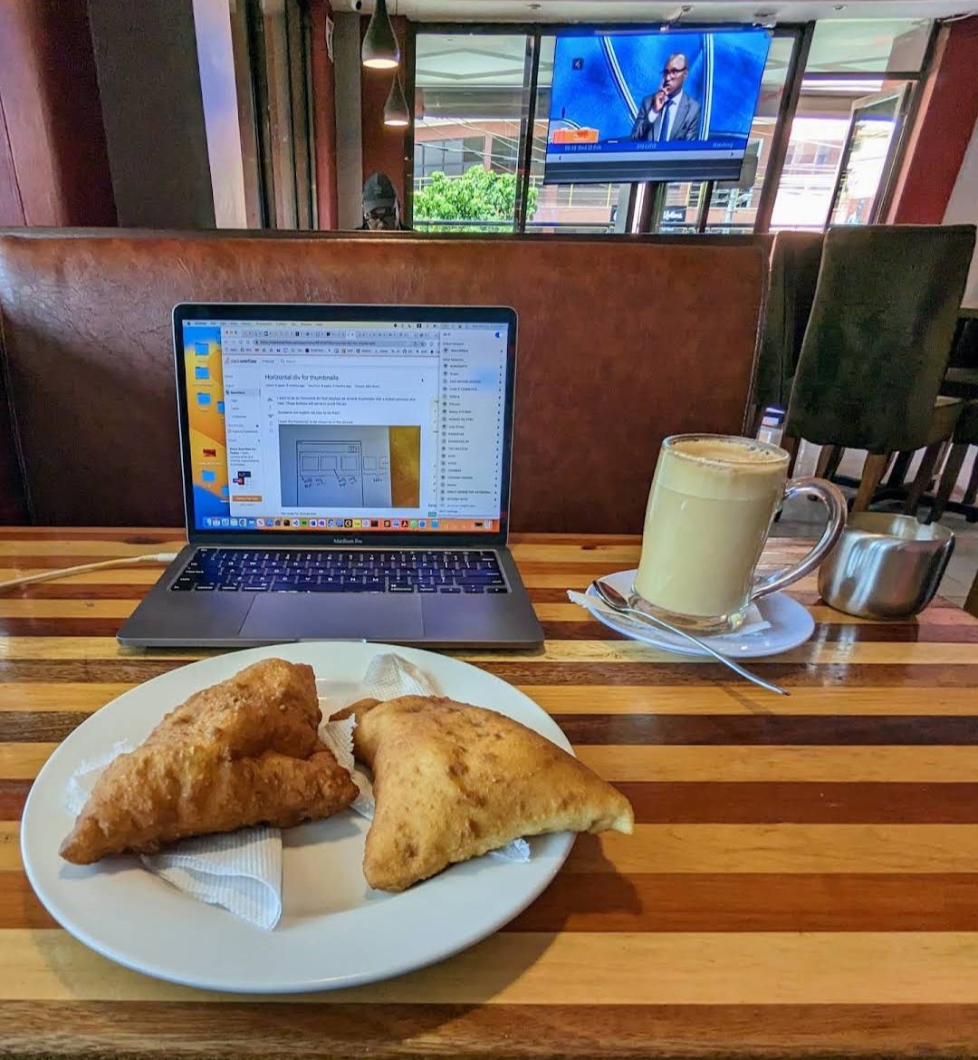 A café latte and samosas on a striped timber table at Andy's